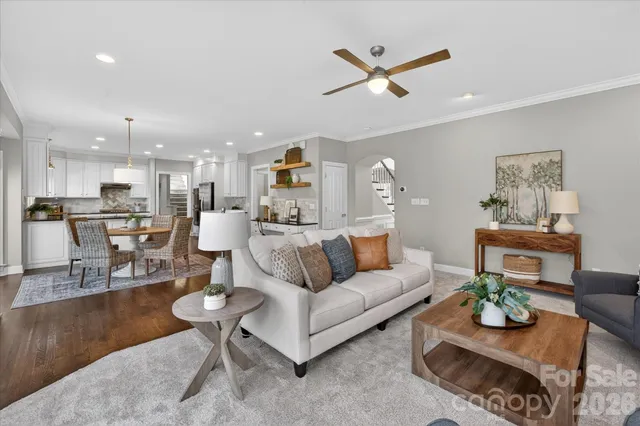 a living room with furniture kitchen view and a chandelier