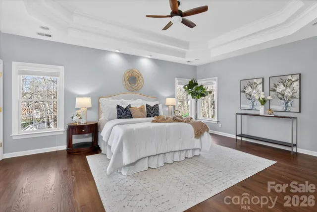 a bedroom with a large bed and wooden floor