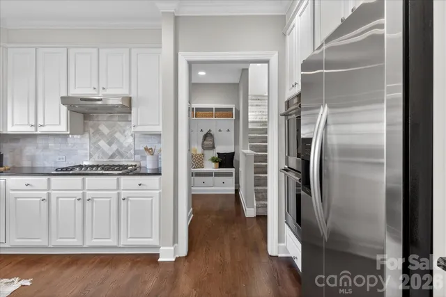a kitchen with stainless steel appliances granite countertop a refrigerator and a sink