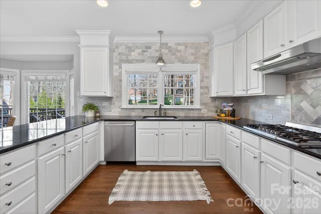 a kitchen with a white cabinets and window