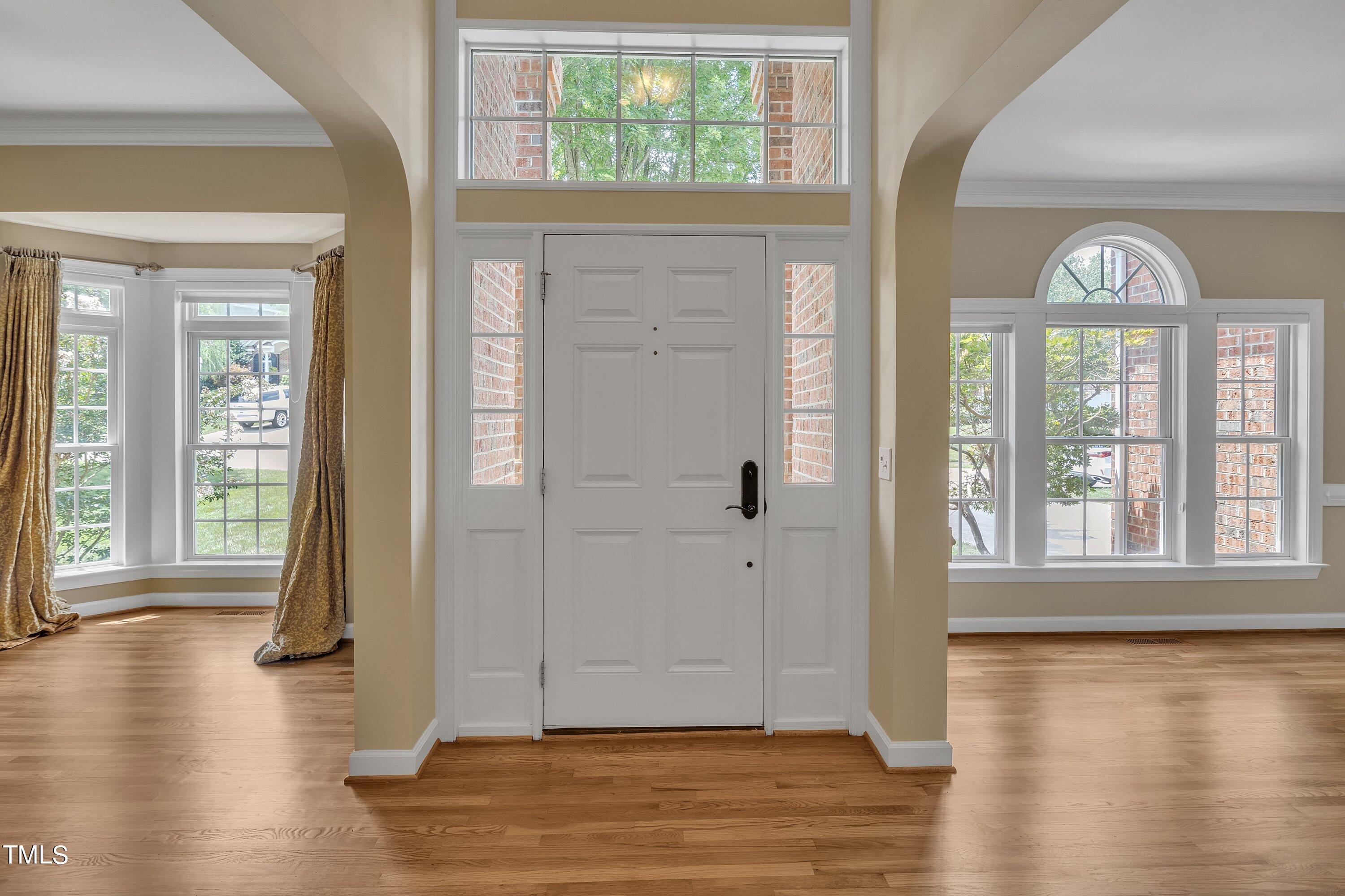 12208 Jasmine Cove Way Raleigh, NC 27614 - Photo 4 of 57 an empty room with wooden floor and windows