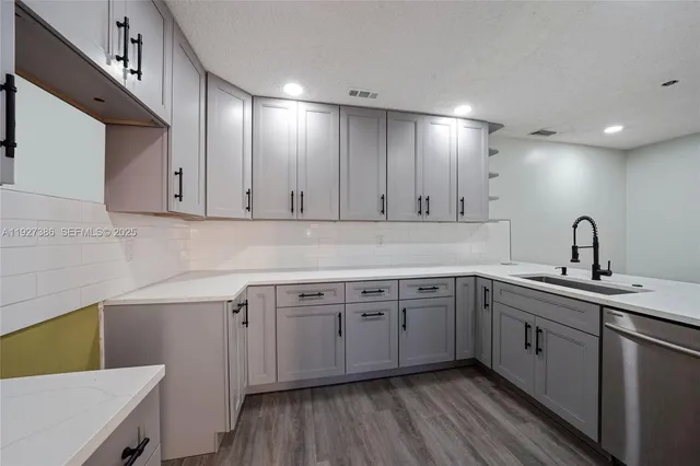 a kitchen with a sink cabinets and wooden floor