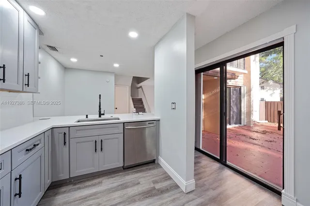 a large kitchen with lot of counter space and wooden floor