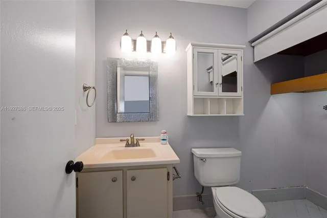 a bathroom with a toilet sink and mirror