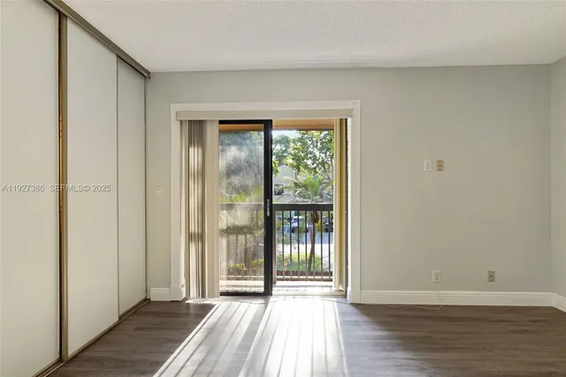 a view of a room with wooden floor and a window
