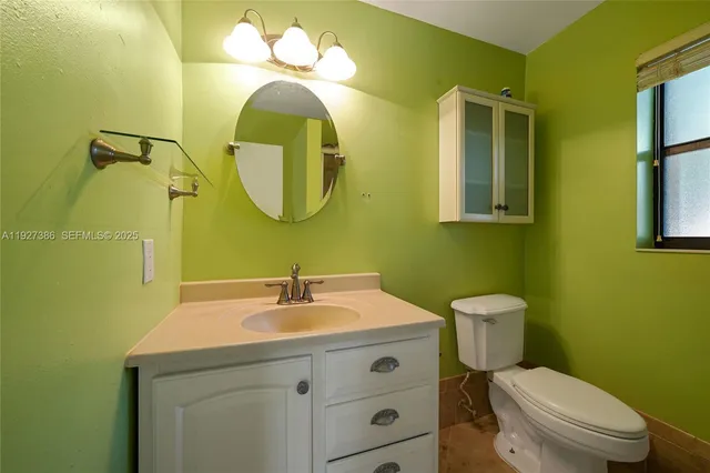 a bathroom with a toilet sink and mirror