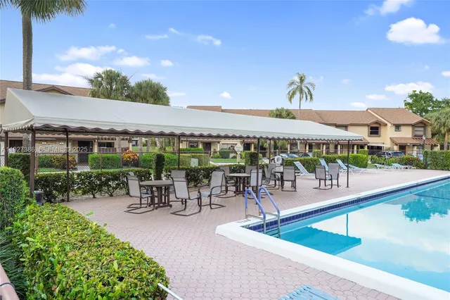 a view of a swimming pool with a patio and a garden