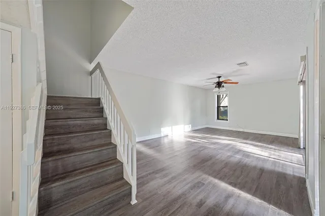 a view of a livingroom with wooden floor and stairs