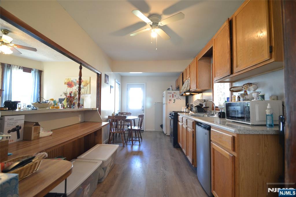 655 Chestnut Street Kearny, NJ 07032 - Photo 11 of 31 a kitchen with stainless steel appliances kitchen island granite countertop a stove a sink a dining table and chairs with wooden floor