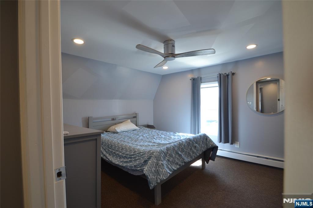 655 Chestnut Street Kearny, NJ 07032 - Photo 25 of 31 a bedroom with a bed and a chandelier