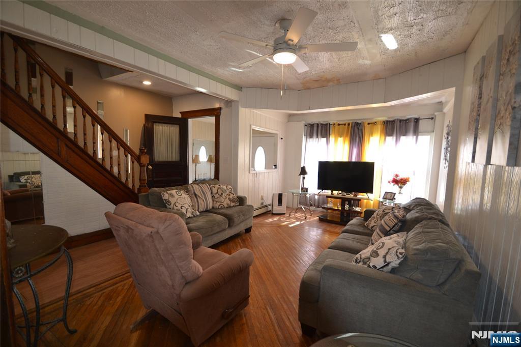 655 Chestnut Street Kearny, NJ 07032 - Photo 9 of 31 a living room with furniture a flat screen tv and a fireplace