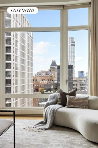 a bedroom with two beds and a large mirror next to a window