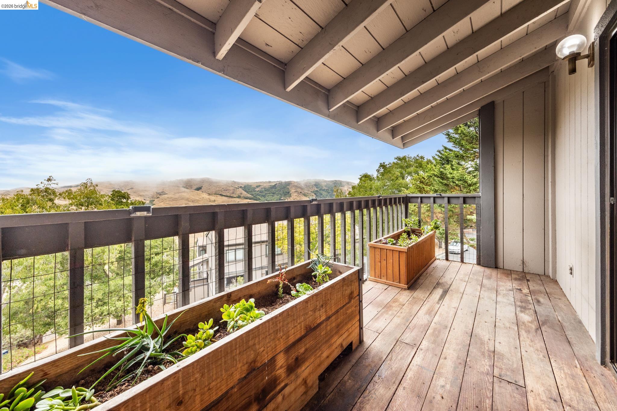 201 Vista Heights Road El Cerrito, CA 94530 - Photo 7 of 32 Balcony featuring wood-finish flooring, a metal railing, and two built-in wooden planters