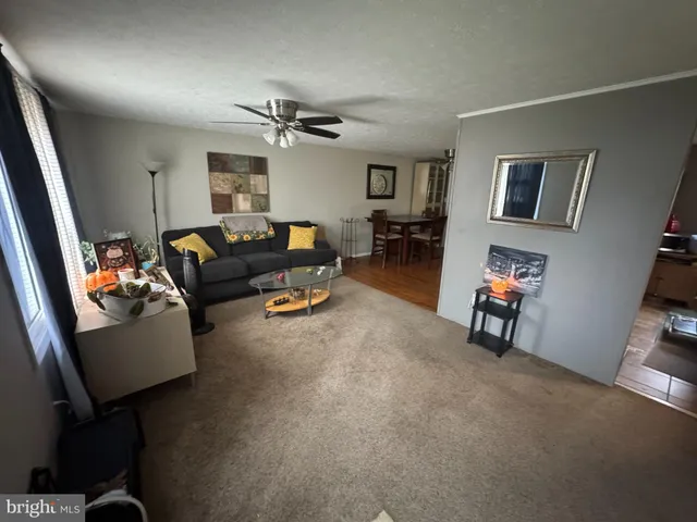 a view of a dining room and livingroom with furniture wooden floor a rug and a clock