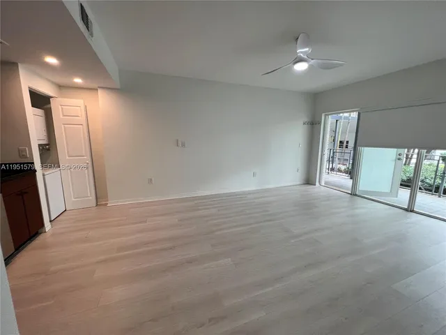 a view of a room with wooden floor and a window