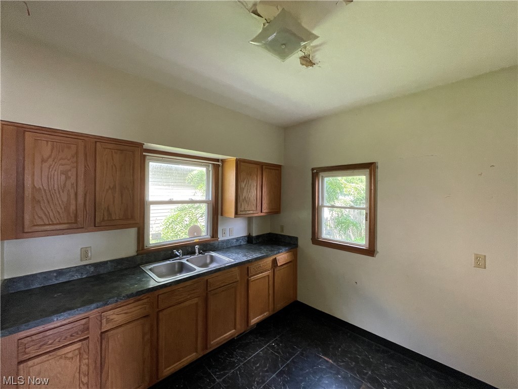 829 Berwin Street Akron, OH 44310 - Photo 2 of 24 Kitchen featuring dark tile flooring, plenty of natural light, dark countertops, and brown cabinets