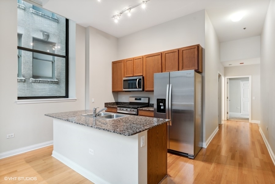 8 West Monroe Street, Unit 500 Chicago, IL 60603 - Photo 6 of 14 a kitchen with granite countertop a refrigerator and a sink