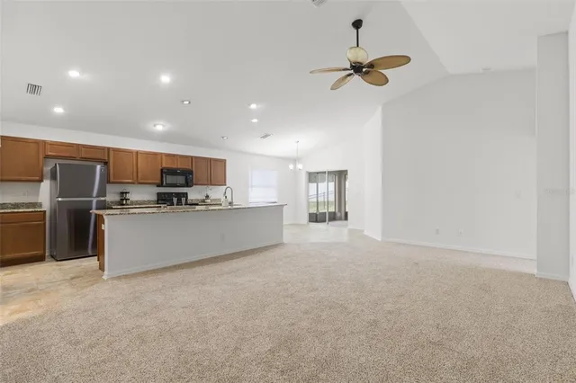 a view of kitchen with cabinets microwave and refrigerator