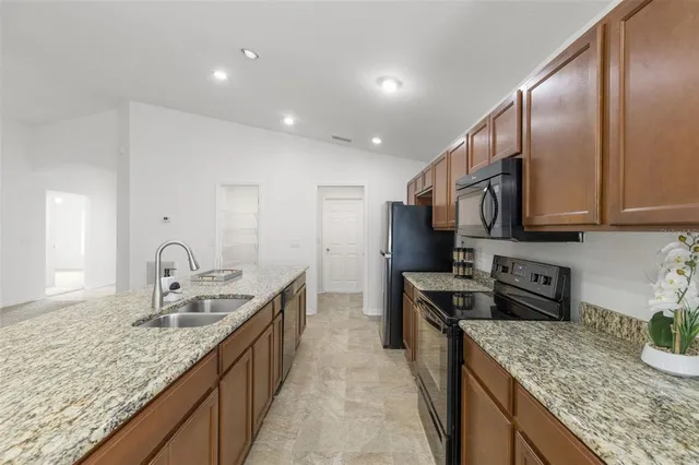 a kitchen with stainless steel appliances granite countertop a sink stove and cabinets