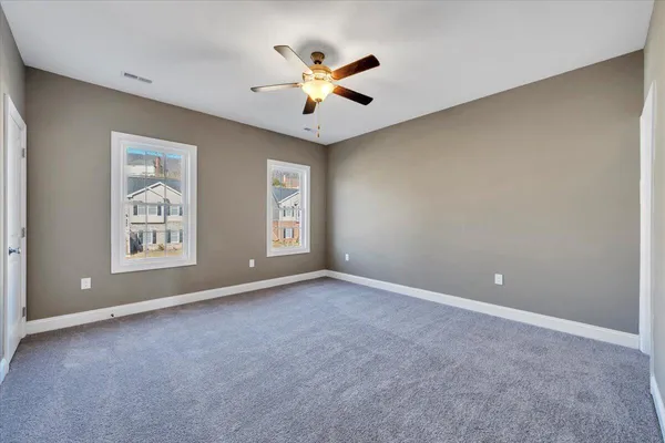 an empty room with window and ceiling fan