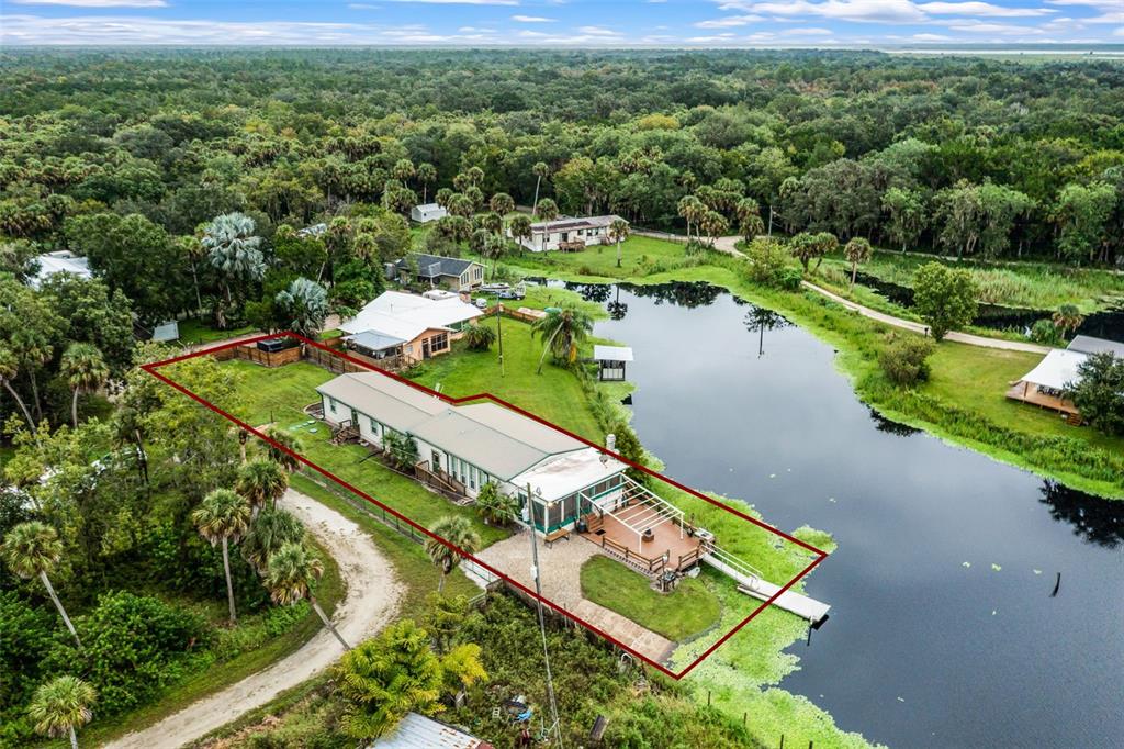 an aerial view of a house with a yard and lake view