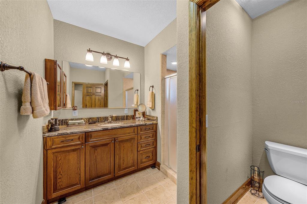 8270 Baxter Point North Mims, FL 32754 - Photo 25 of 50 a spacious bathroom with a granite countertop sink a toilet a mirror and shower