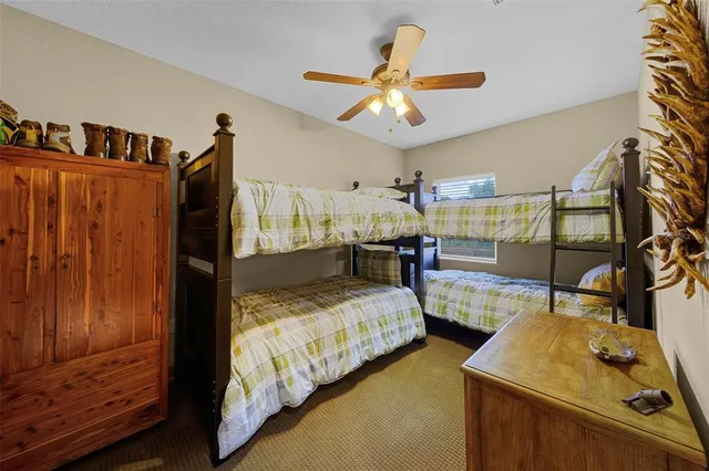 a bedroom with two beds and ceiling fan