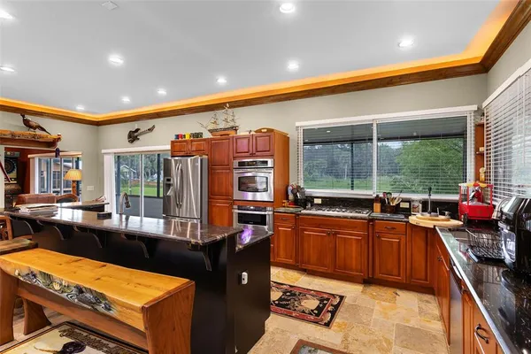 a kitchen with stainless steel appliances kitchen island granite countertop a sink and a stove