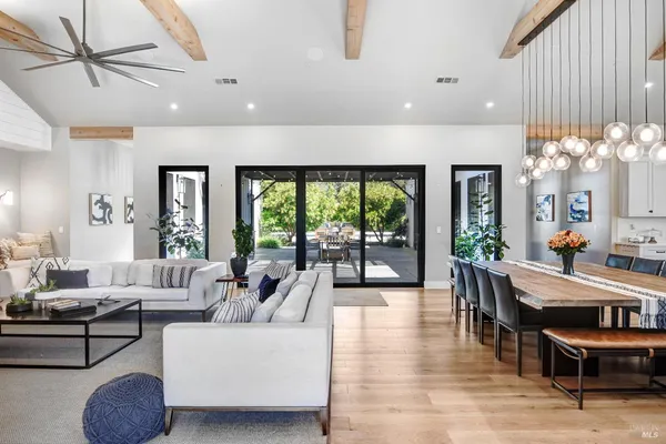a dining room with wooden floor a chandelier a wooden table and chairs