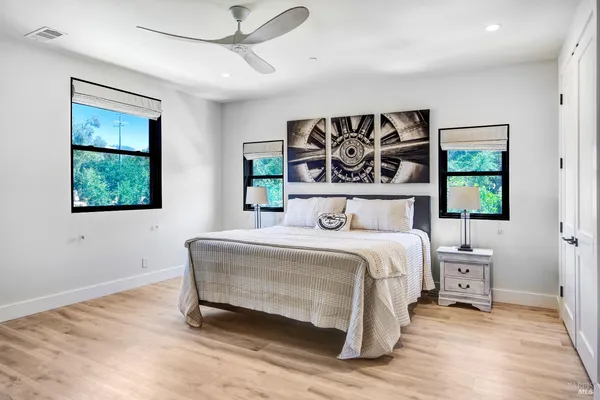 a kitchen with stainless steel appliances granite countertop a dining table chairs refrigerator and sink