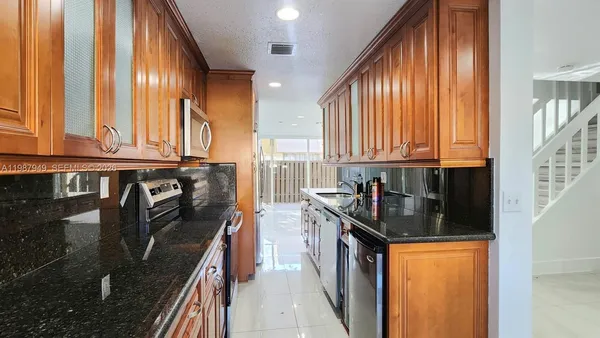 a kitchen with stainless steel appliances granite countertop sink stove and cabinets