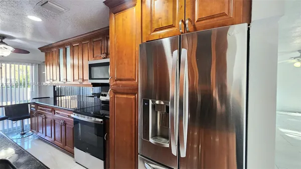 a kitchen with stainless steel appliances granite countertop a refrigerator and a sink