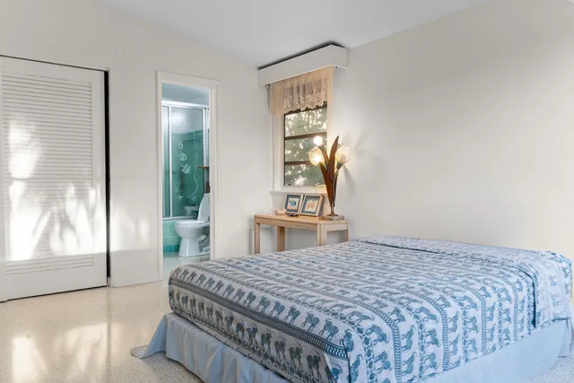 a spacious bedroom with a bed and a window