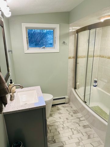 a bathroom with a sink a toilet and shower