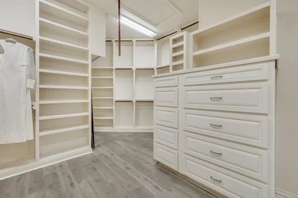 a view of walk in closet with empty racks
