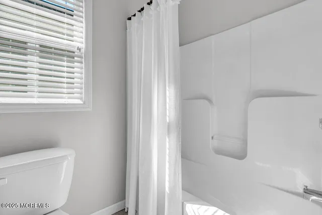 a bedroom with a bed a mirror and a window