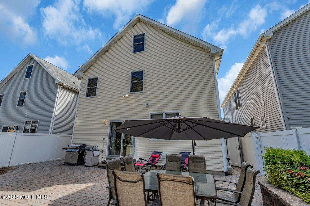 1825 Pine Terrace Lake Como, NJ 07719 - Photo 45 of 53 a patio with a table and chairs under an umbrella