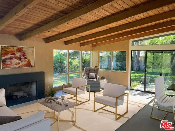 a living room with furniture a fireplace and a floor to ceiling window