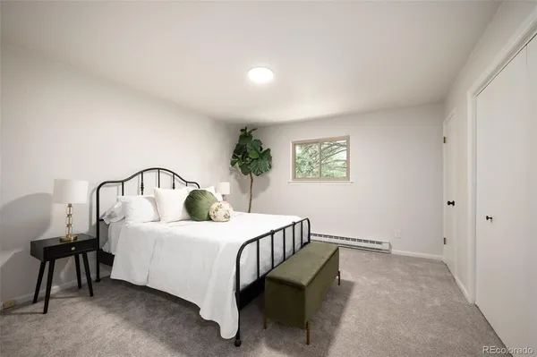 a bedroom with a bed a table and painting on the wall