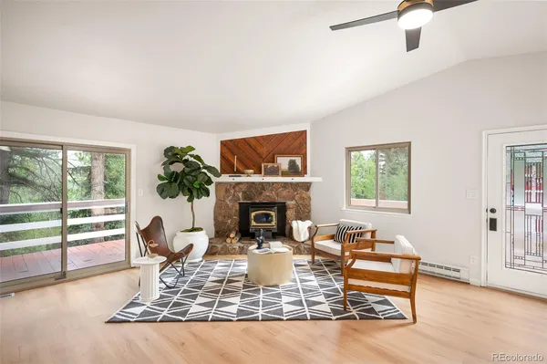 a living room with furniture a fireplace and a floor to ceiling window