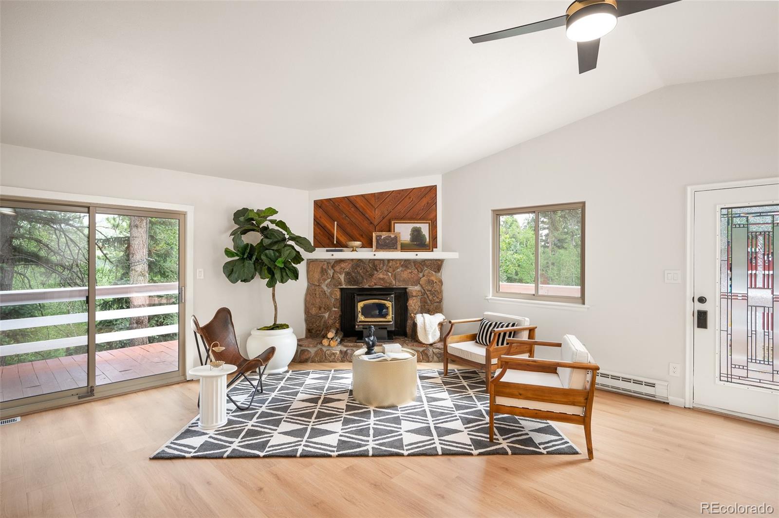 19424 Silver Ranch Road Conifer, CO 80433 - Photo 2 of 34 a living room with furniture a fireplace and a floor to ceiling window