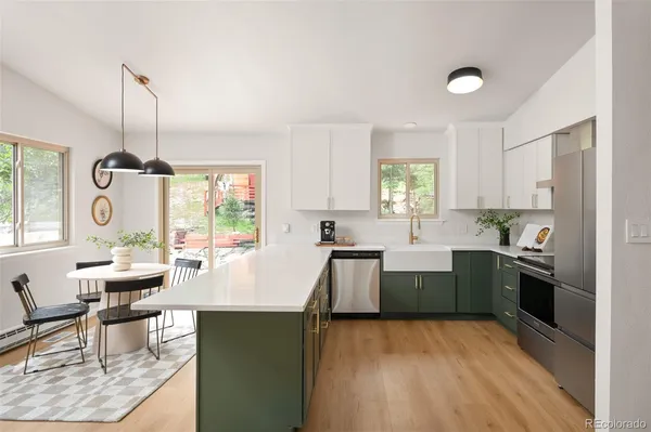 a large kitchen with kitchen island white cabinets and stainless steel appliances