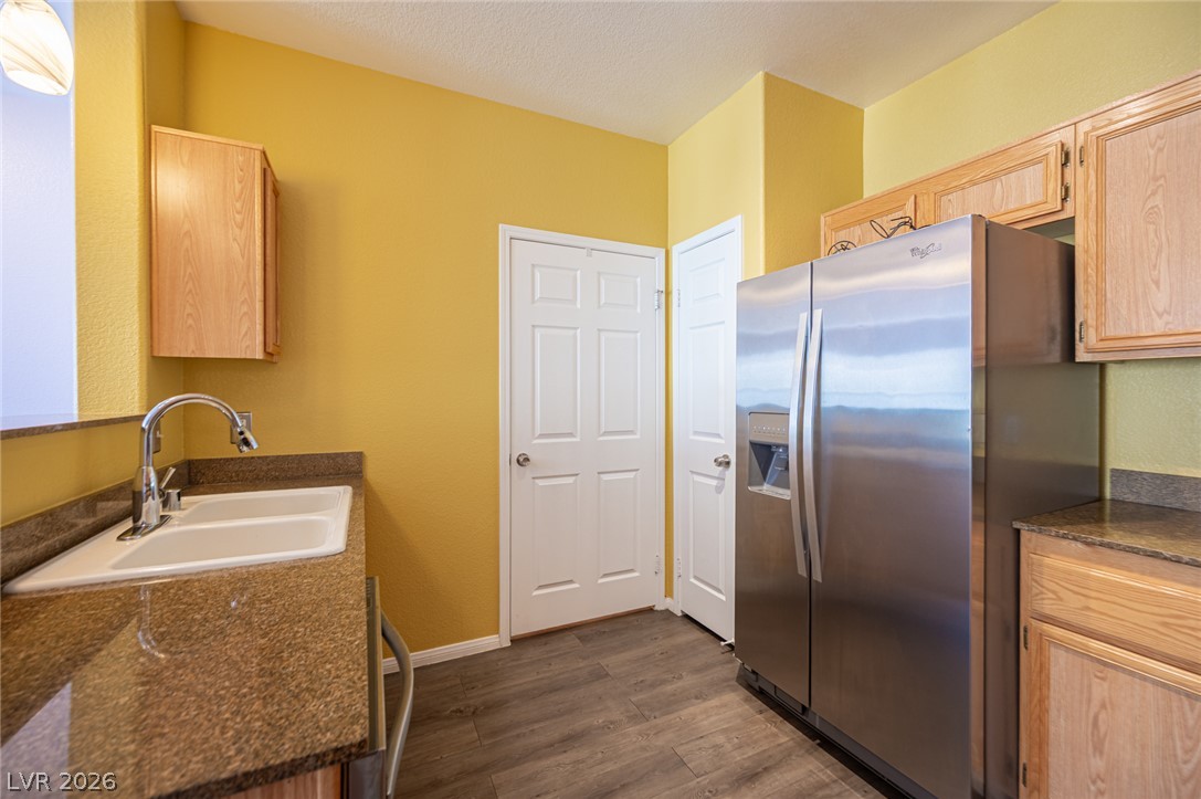 10550 West Alexander Road, Unit 2014 Las Vegas, NV 89129 - Photo 19 of 43 Richly toned wood cabinetry and stone countertops anchor this functional culinary workspace.