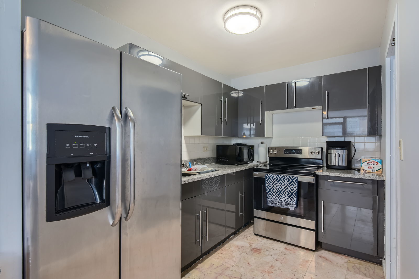 6301 North Sheridan Road, Unit 10F Chicago, IL 60660 - Photo 10 of 19 a kitchen with a sink a refrigerator and cabinets