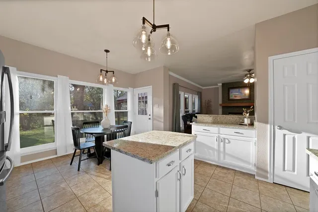 a large kitchen with kitchen island a large counter space dining table and stainless steel appliances
