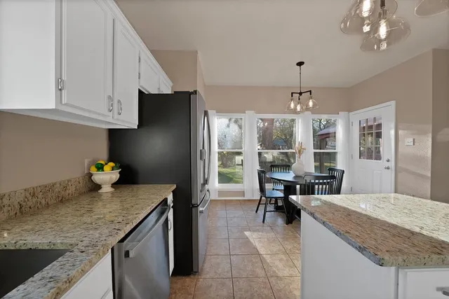 a kitchen with granite countertop cabinets a dining table and chairs