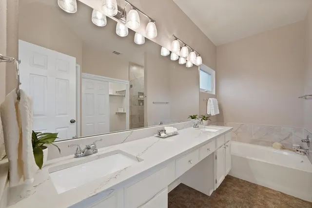 a spacious bathroom with a double vanity sink and a large mirror