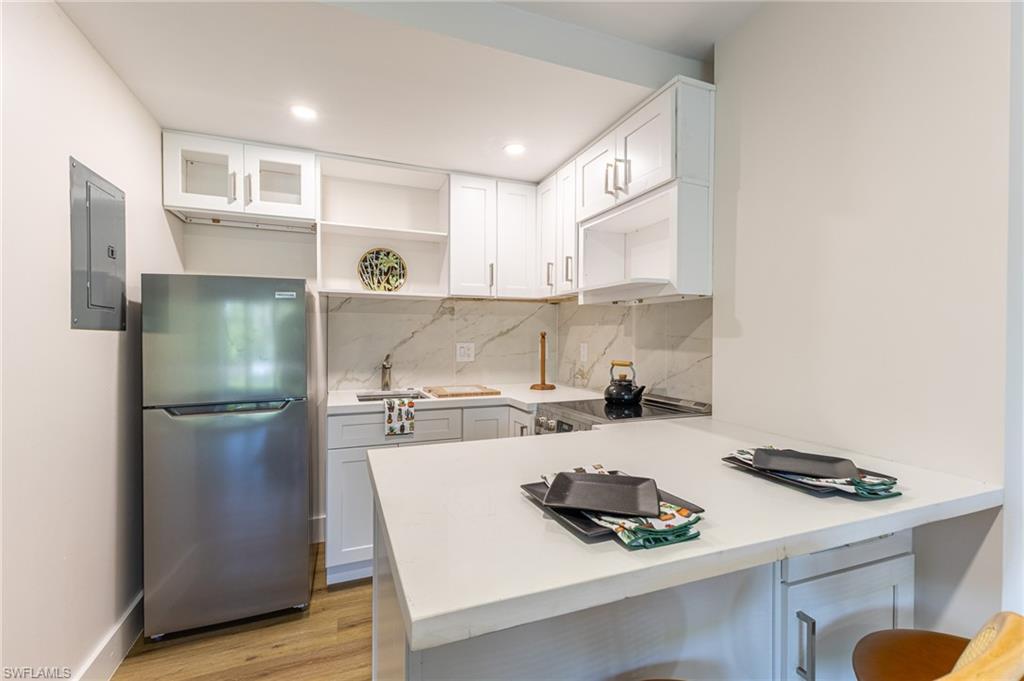 5 Bluebill Avenue, Unit 105 Naples, FL 34108 - Photo 13 of 26 a kitchen with a refrigerator and a stove