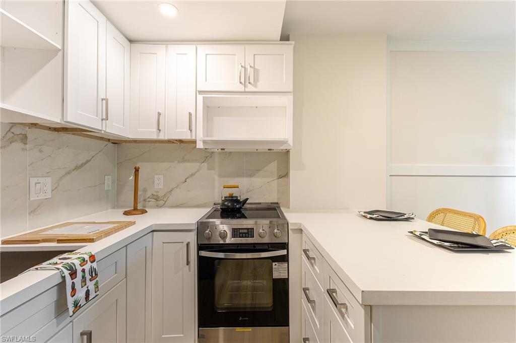 5 Bluebill Avenue, Unit 105 Naples, FL 34108 - Photo 14 of 26 a kitchen with a sink stove and cabinets