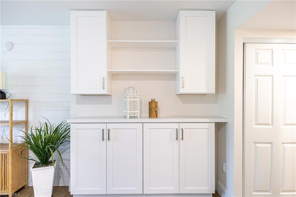 5 Bluebill Avenue, Unit 105 Naples, FL 34108 - Photo 17 of 26 a kitchen with white cabinets and potted plant